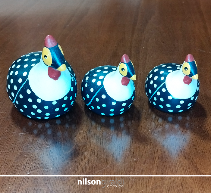 Foto de três galinhas de angola de argila, pintadas, de diferentes tamanhos.